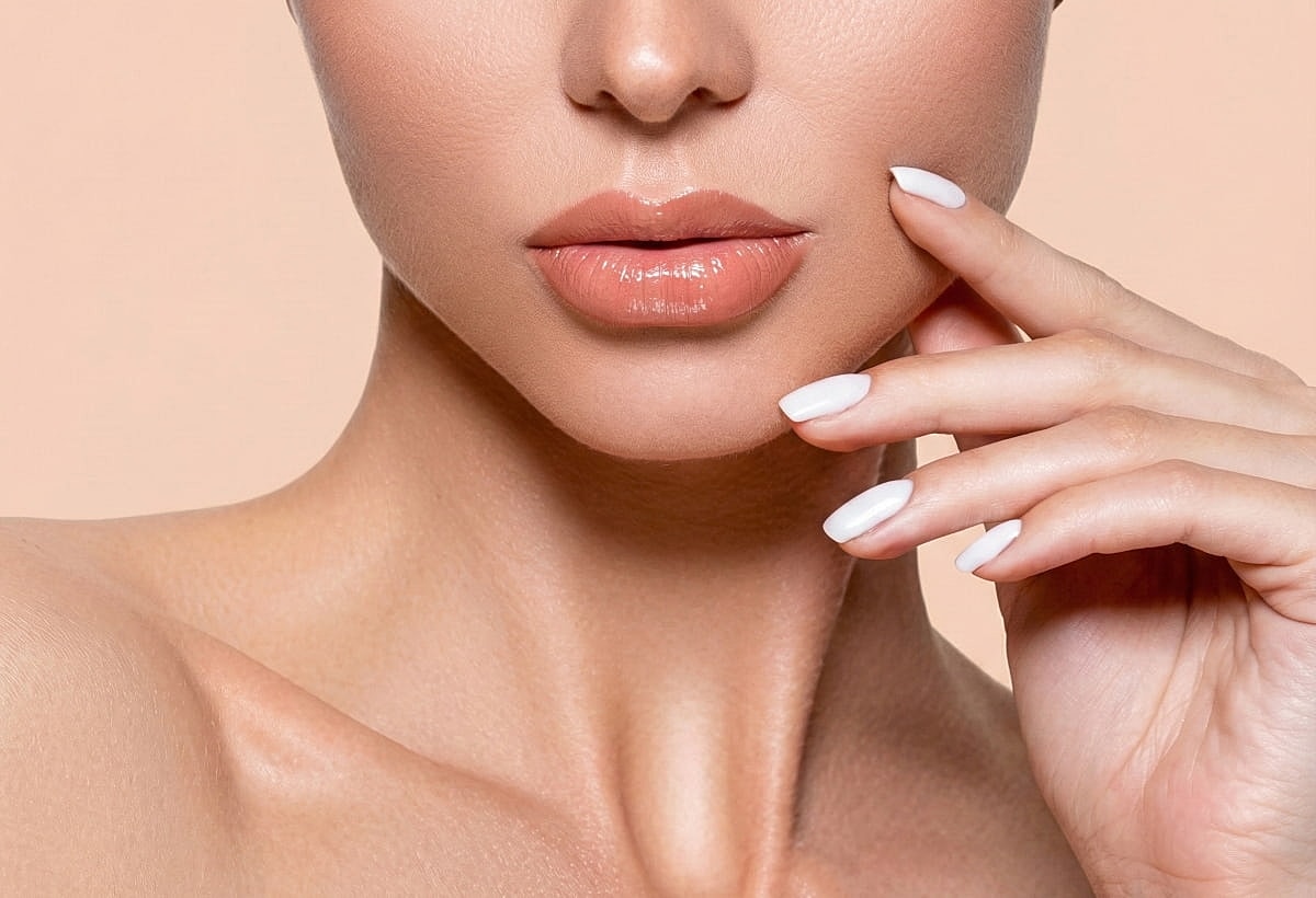 Close-up of woman's face and manicured nails.