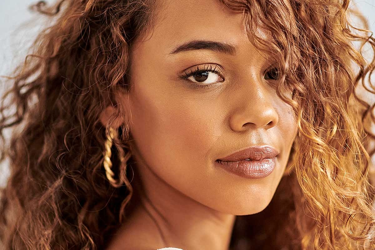 Woman with curly hair and earrings.