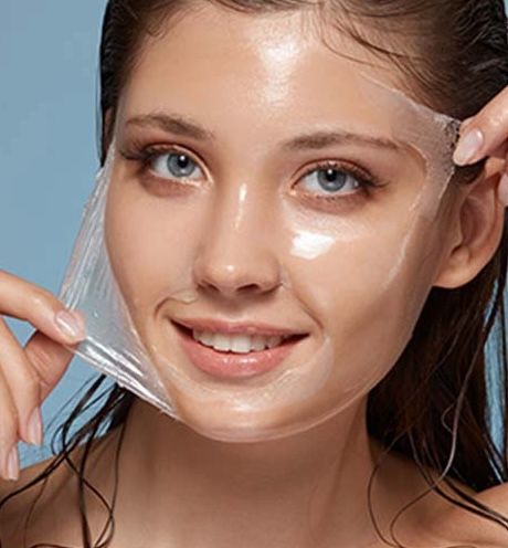 Woman applying a facial mask treatment.