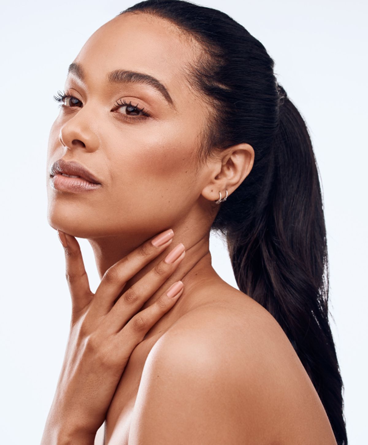 Smiling woman touching her face gently.