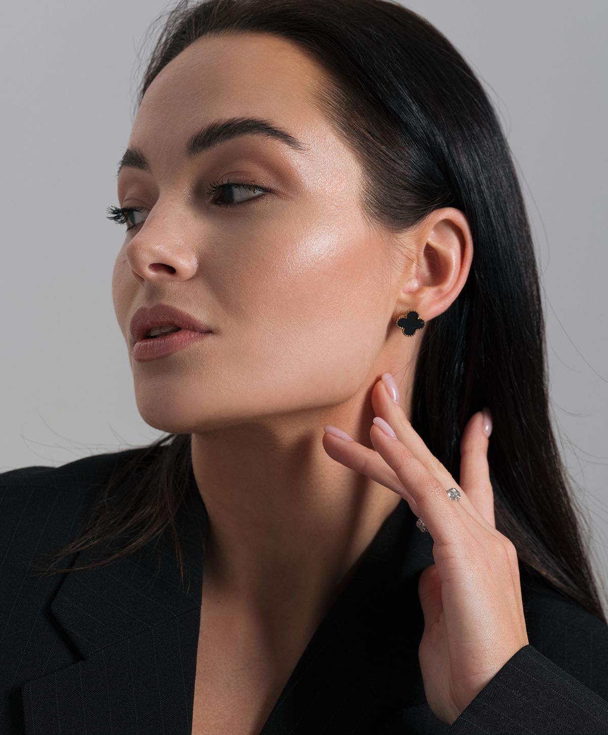 Woman wearing elegant jewelry and stylish attire.