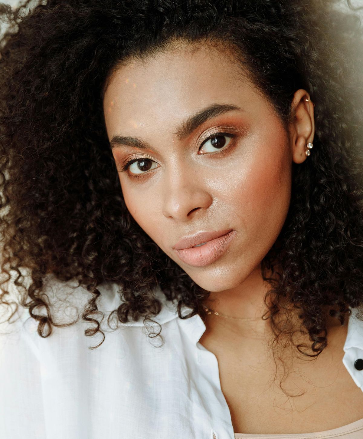 Woman wearing elegant jewelry and stylish attire.