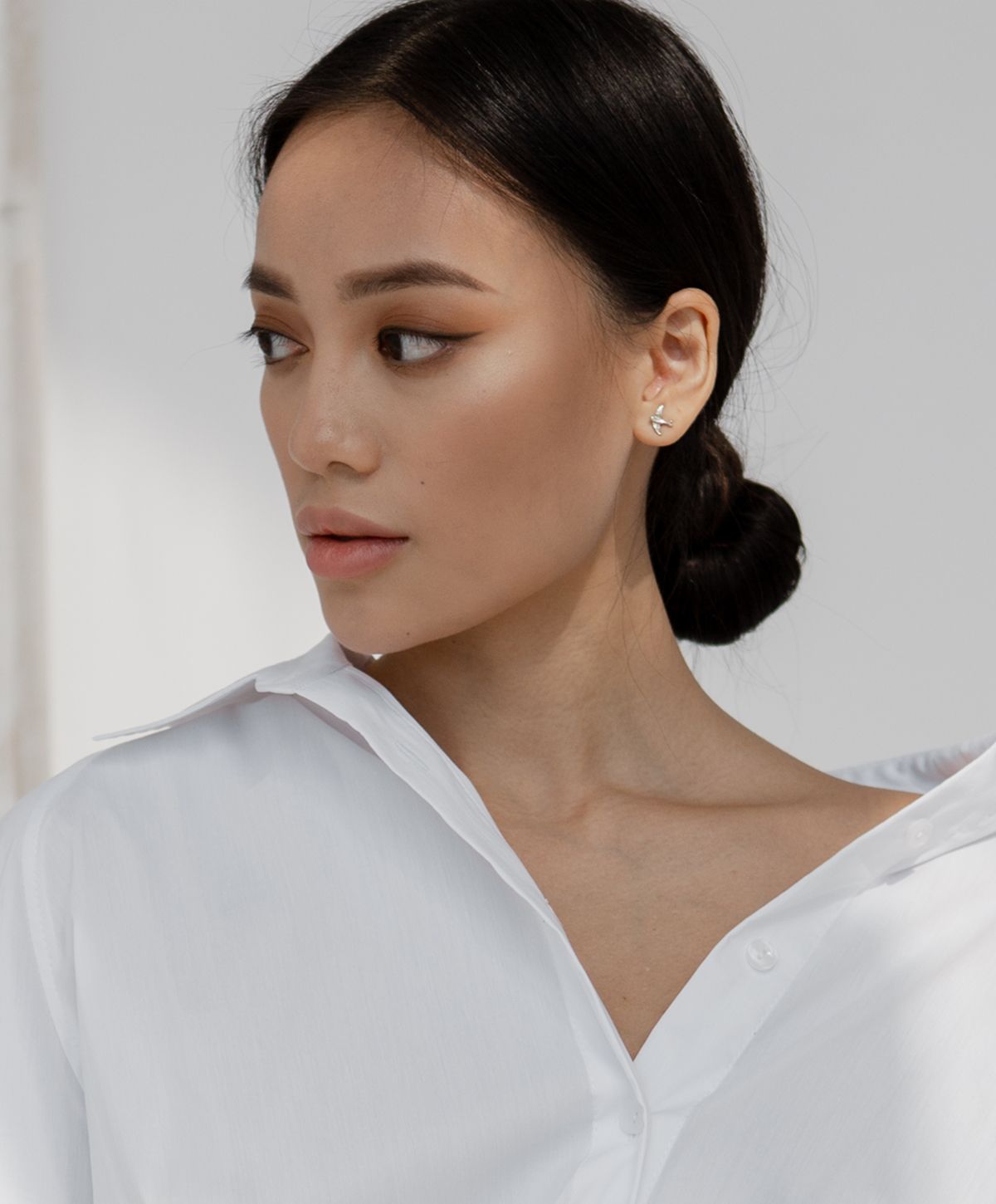 Woman in white shirt with elegant hairstyle.