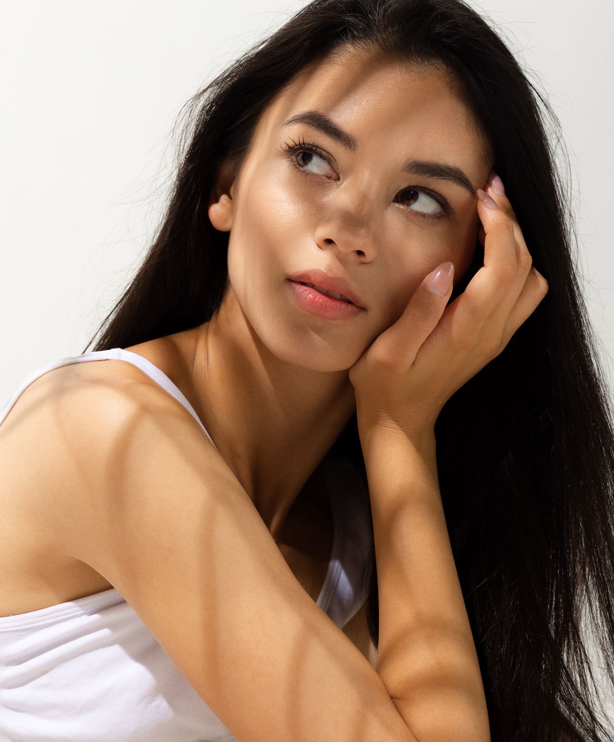 Woman with long hair, thoughtful expression and shadows.