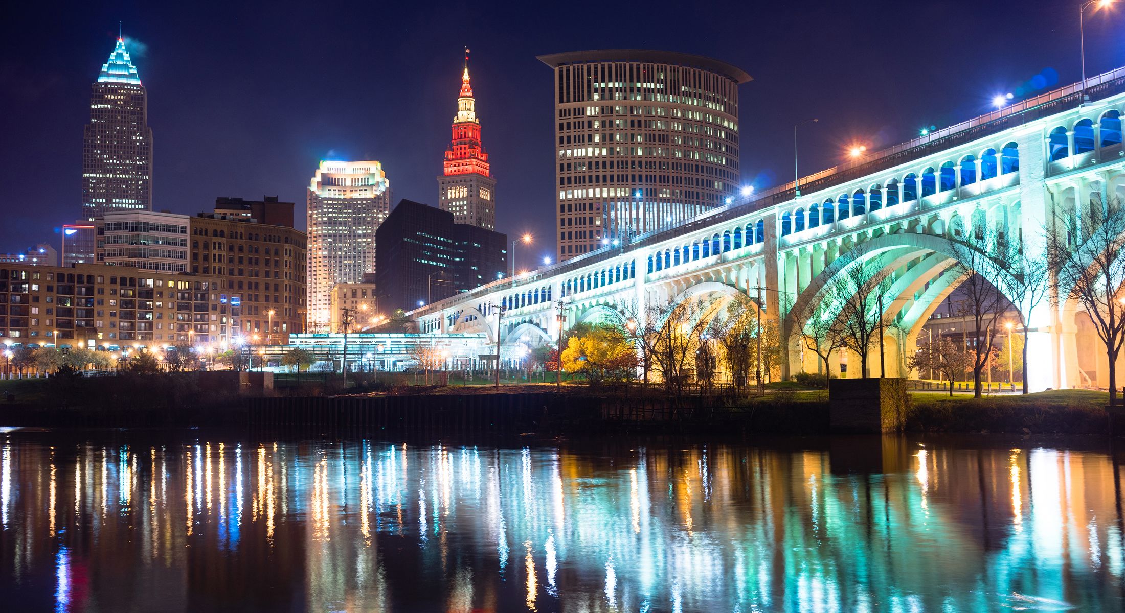 Cleveland skyline at night with illuminated bridge.