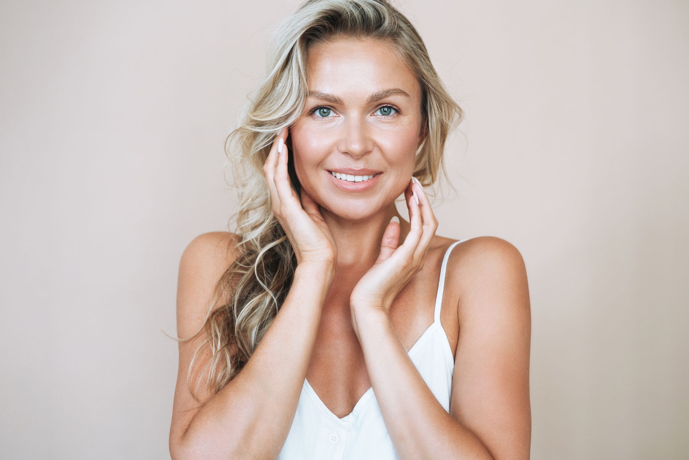 Smiling woman with long blonde hair, natural makeup.