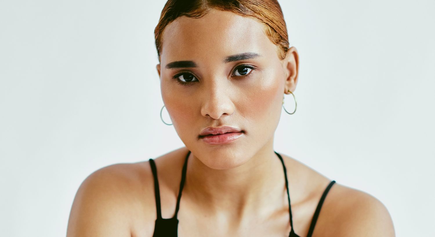 Close-up portrait of a woman with sleek hairstyle.